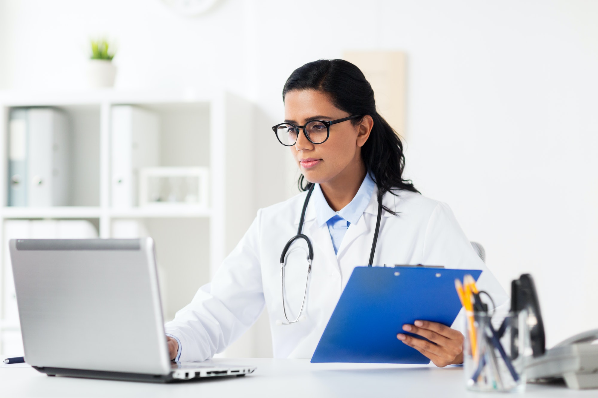 doctor with laptop and clipboard at hospital